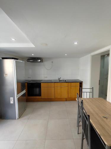 eine Küche mit Holztisch und Edelstahlkühlschrank in der Unterkunft Mobilierte Monteuerswohnungen mit 2 Betten Stuttgart, Böblingen, Reutlingen, Waldenbuch - HeimbachEG in Waldenbuch