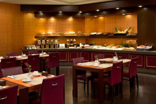 Un restaurante con mesas y sillas y un bar. en Starhotels Metropole, en Roma