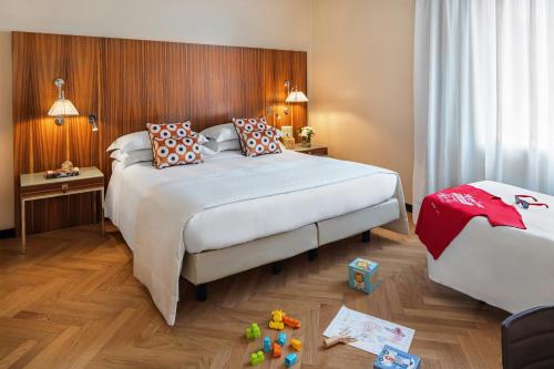 a bedroom with two beds and toys on the floor at Starhotels Anderson in Milan