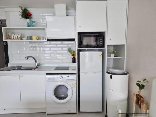 a kitchen with a washing machine and a microwave at 스타샤인 in Busan