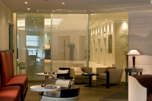 a restaurant with tables and chairs and a lobby at Starhotels Grand Milan in Saronno