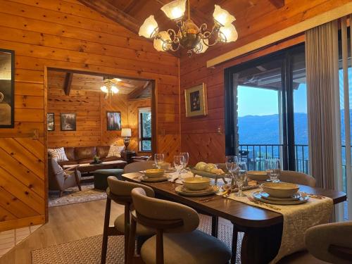 Un comedor con una mesa y sillas y un sofá. en NEW LISTING, Near Yosemite South Gate entrance and town, King bed, Hot Tub, BBQ, Firepit & Mountain Views, en Oakhurst