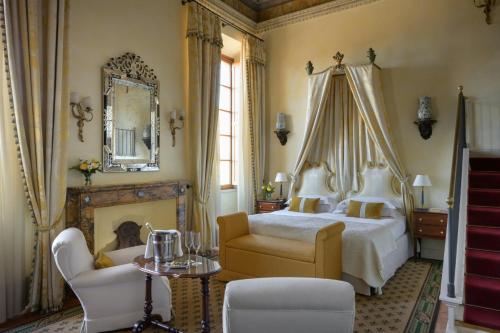 a bedroom with a bed and a chair and a mirror at Grand Hotel Continental Siena - Starhotels Collezione in Siena