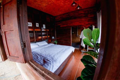 a bedroom with a bed in a wooden room at Mae Buya Coffee Farm Stay in Ban Huai Pong Nam Ron