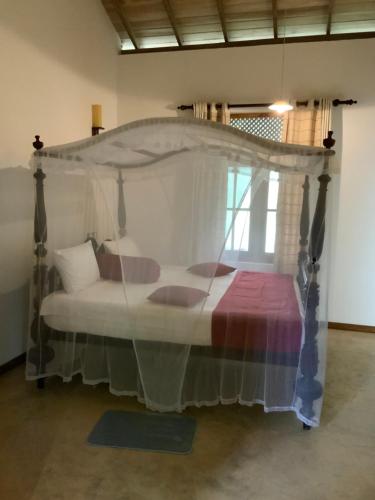 a bedroom with a bed with a canopy at Lali Villa in Galle