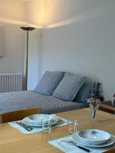 a table with two plates on top of a bed at Studio rénové avril 2024 wifi et parking in Le Port-Marly