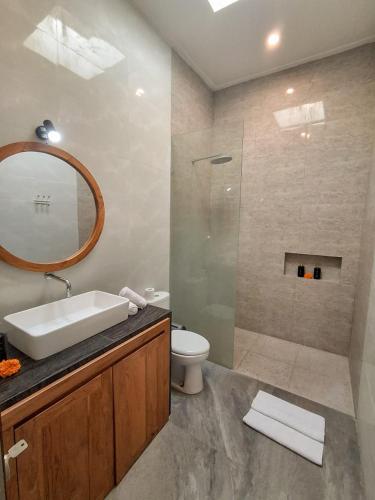 a bathroom with a sink and a toilet and a mirror at Casagana by Gana Management Canggu in Dalung