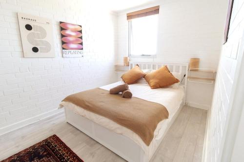 a bedroom with a bed with a teddy bear on it at Heart of Freo - Ocean Views in Fremantle