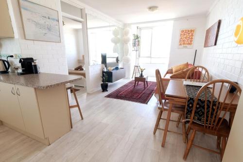a kitchen and living room with a table and chairs at Heart of Freo - Ocean Views in Fremantle