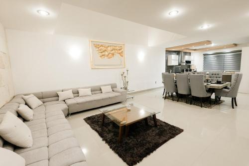 un salon avec un canapé et une salle à manger dans l'établissement Residencia privada en León, à Cañada