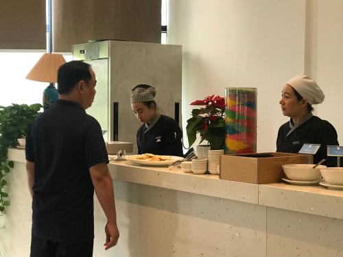 a man and a woman standing in a kitchen at Cam Ranh Resort in Cam Ranh
