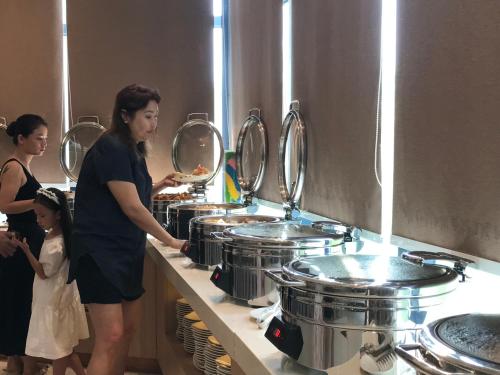 a woman and a child standing in front of a buffet at Cam Ranh Resort in Cam Ranh