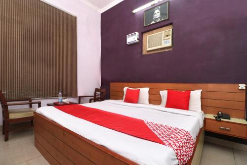 a bedroom with a large bed with red and white pillows at Hotel O Star INN in Jalandhar