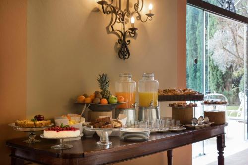 um buffet de comida em uma mesa com sobremesas e bebidas em Villa Michelangelo Vicenza – Starhotels Collezione em Arcugnano