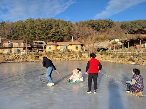 eine Gruppe von Menschen, die im Wasser spielen in der Unterkunft Red Clay Pension Dream Conversation in Donghae