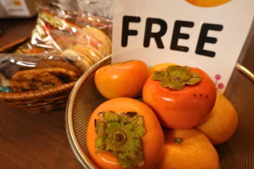 福岡市にある福岡ゲストハウスJikkaの無料のサインが書かれたテーブルの上にトマトのボウル