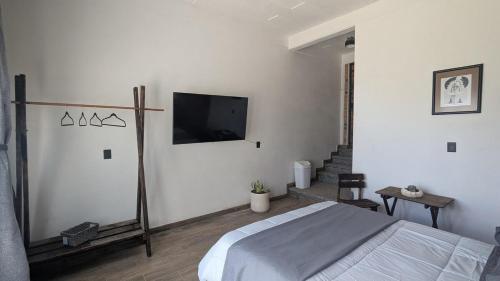 a bedroom with a bed and a flat screen tv at Casa Ñogi 