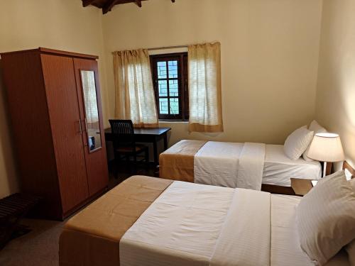 a hotel room with two beds and a desk at Watawala Tea Garden in Rozella