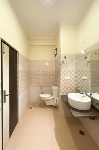 a white bathroom with two sinks and a toilet at The Kasauli woods in Kasauli