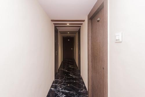 um corredor com piso de mármore preto em um quarto em Hotel O Shalimar em Mumbai