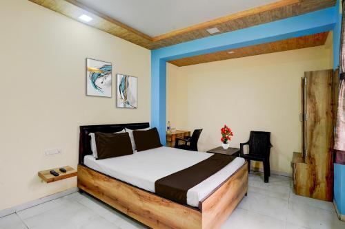 Un dormitorio con una cama y una mesa y sillas. en Hotel O Bhiwandi Road Railway Station Formerly Shivneri, en Umberpāda