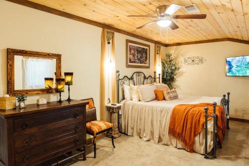 a bedroom with a bed and a dresser and a mirror at Escape to Villa Serena in Dahlonega