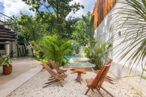 a patio with two chairs and a swimming pool at Casa Wayra Tulum - Boutique Condos in Tulum