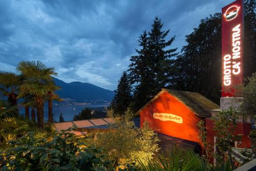 a sign for a cocacola building with a mountain in the background at Boutique Hotel Albergo Brione in Locarno