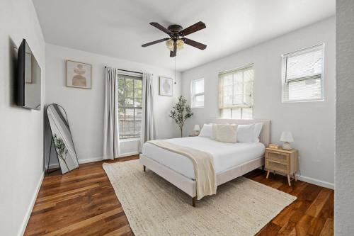 a white bedroom with a bed and a ceiling fan at Central East Austin Luxury Hot Tub & Game Room in Austin