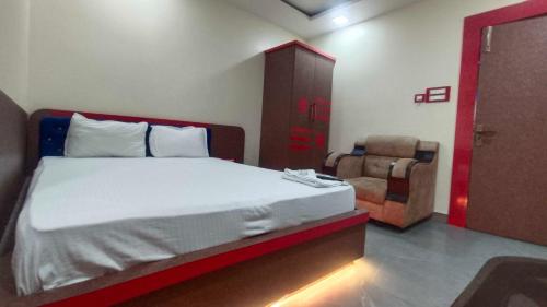 a bedroom with a large bed and a chair at Collection O A&M Regency, WEBLE More in Thākurdwari