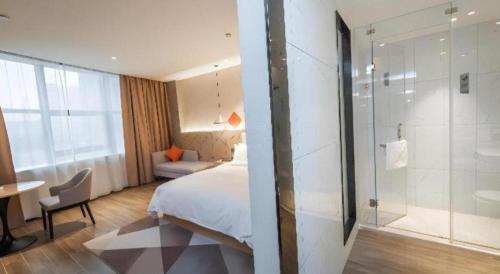 een hotelkamer met een bed en een douche bij Borrman Hotel Yongzhou High Speed Railway Station in Guzhuting