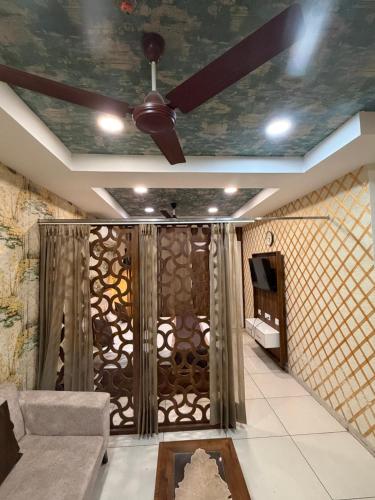 a living room with a ceiling fan and a couch at The Cove in Zirakpur