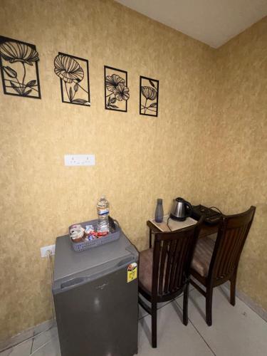 a room with a refrigerator and a chair and a table at The Cove in Zirakpur