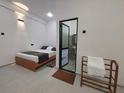 a bedroom with a bed and a mirror at Paboda Residency in Minuwangoda