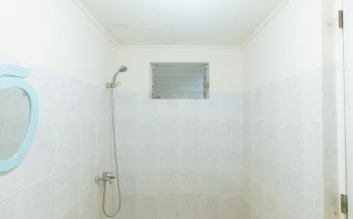 a white bathroom with a shower and a mirror at Winland JY7 Cebu by RedDoorz in Cebu City