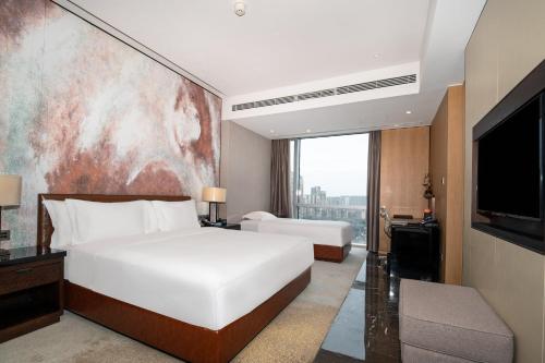 a hotel room with a bed and a television at Crowne Plaza Chengdu Wenjiang by IHG in Chengdu