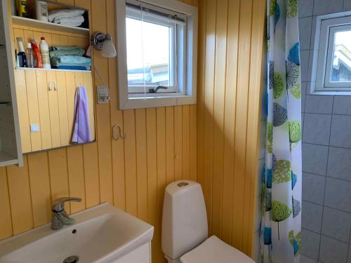 een badkamer met een wastafel en een toilet en een raam bij Cozy Beach House In The First Row in Karrebæksminde
