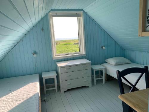 een kleine kamer met een bed en een raam bij Cozy Beach House In The First Row in Karrebæksminde