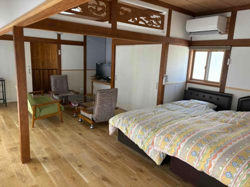 a bedroom with a bed and a desk and chairs at TC1 Nagano - Vacation STAY 10022v in Okaya