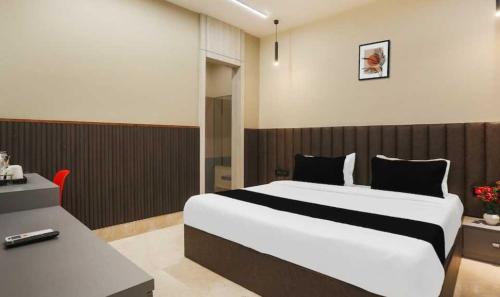 KaliānpurにあるTownhouse Oak CSJMU Kanpur Formerly Shree Dev Villaの大きなベッドと机のある寝室