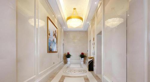 een hal met witte muren en een kroonluchter bij Vienna Hotel Baoshan Yongchang Road in Baoshan