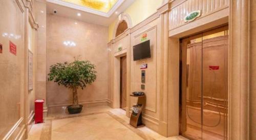 een hal met een potplant in een gebouw bij Vienna Hotel Fujian Yong'an South Railway Station in Yong'an