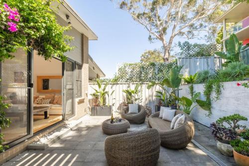 an outdoor patio with couches and chairs and plants at 6A Hough Street - Sophisticated pet friendly home with air con, wi-fi and linen provided in Nelson Bay