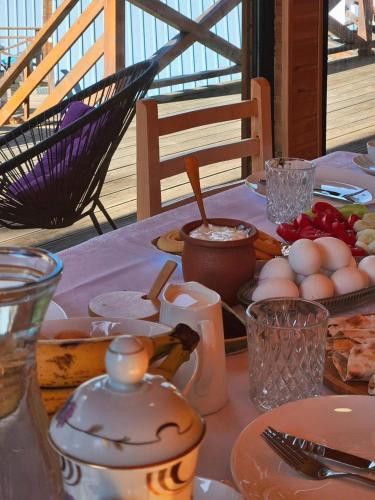 una mesa con huevos y otros alimentos. en Cozy Cottages, en Mestia