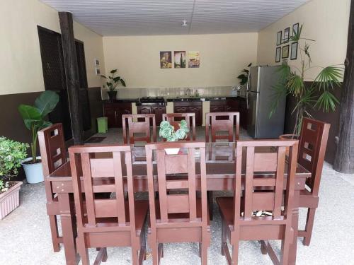 a dining room with a table and chairs and a refrigerator at Mountain Side Travellers Inn in Zambales