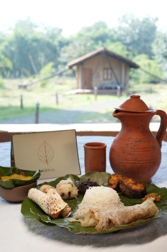 un plato de comida en una mesa con un jarrón en Sakhua, en Tāla