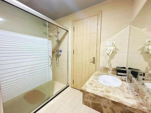 a bathroom with a sink and a shower at Bashan Hotel in Xiamen
