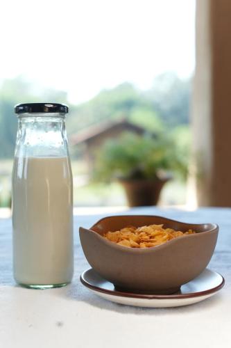 a bowl of cereal next to a glass of milk at Sakhua in Tāla