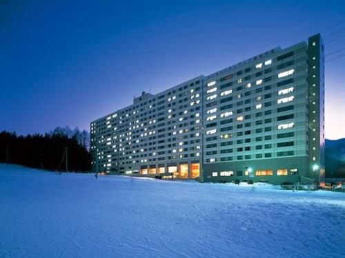 a large building in the snow at night at 47 - Snow Village Cozy Lodge Yuzawa in Yuzawa