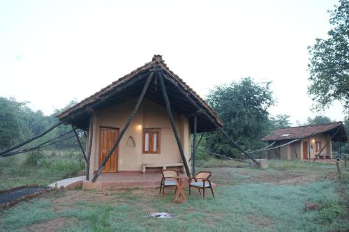 una pequeña cabaña con dos sillas delante en Sakhua, en Tāla